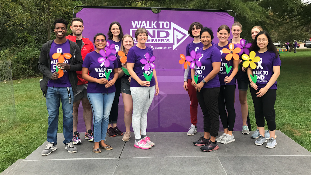 The AANCL and the Human Factors and Aging Lab staff members posing in front of the Walk to End Alzheimer's banner
